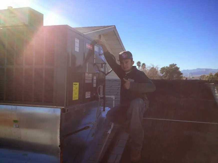 HVAC technician performing HVAC Inspection on a rooftop unit in Uxbridge